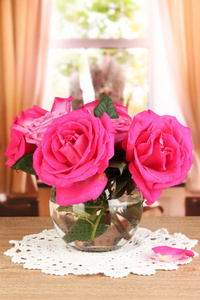 窗口背景上的木桌上花瓶里美丽的粉红色玫瑰