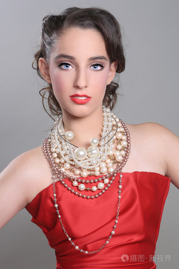 漂亮的红主题模特穿上很多的珍珠