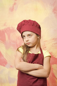 小女孩厨师与严肃的面孔，在帽子和围裙
