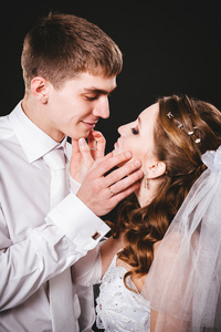 新郎在婚礼上亲吻新娘。黑色背景
