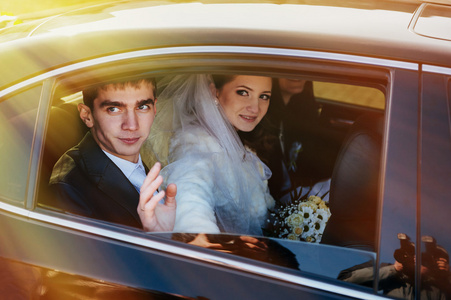 新娘和新郎在婚礼当天的豪华轿车里接吻