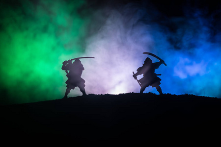 两个武士的剪影在决斗.图片与两个武士和日落的天空.选择性聚焦照片