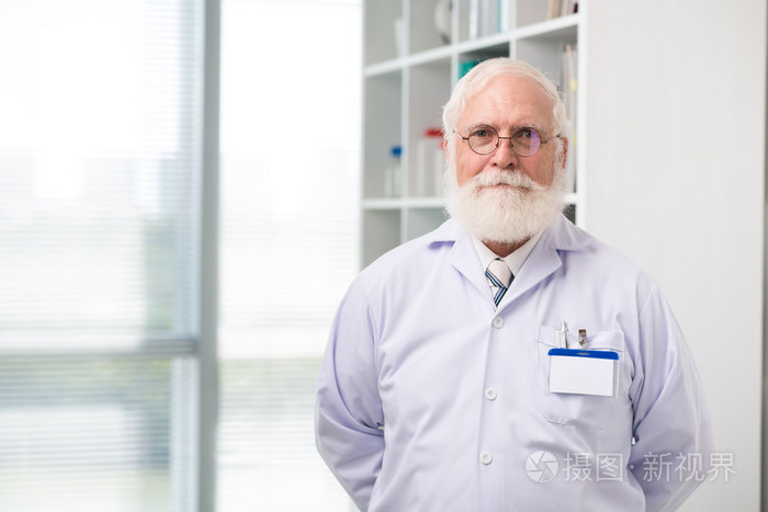 看着摄像机的老年的科学家