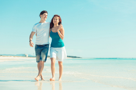 加勒比沙滩上散步的年轻夫妇