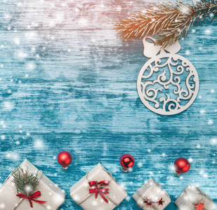 圣诞蔚蓝背景与手工的礼物和一棵杉木树与玩具在它。文本的空间。顶部视图。雪和轻的作用
