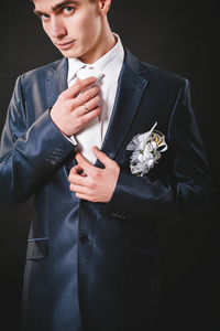婚礼新郎准备在西装的手。黑色工作室背景