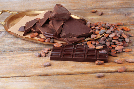 裂纹的巧克力和可可豆木背景上
