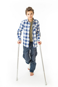 十几岁的男孩，在他的右腿上的绷带与拐杖