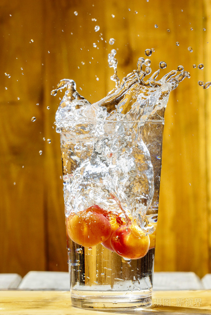 水在玻璃飞溅.在炎热的夏天一天杏饮料