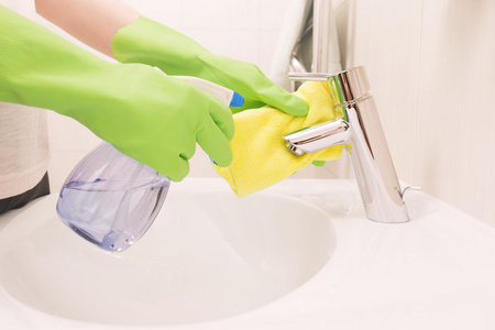 女人做家务在浴室,清洗水槽和水龙头与 sp照片