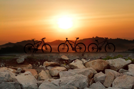 山地自行车在草原上的日落的剪影
