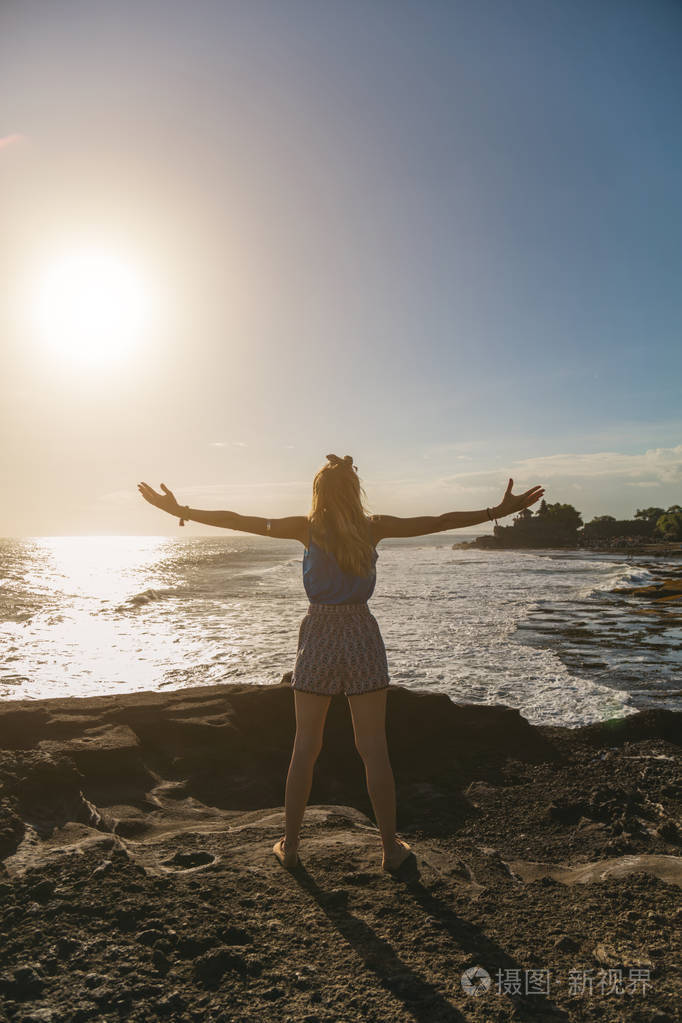 女孩张开双臂享受大海