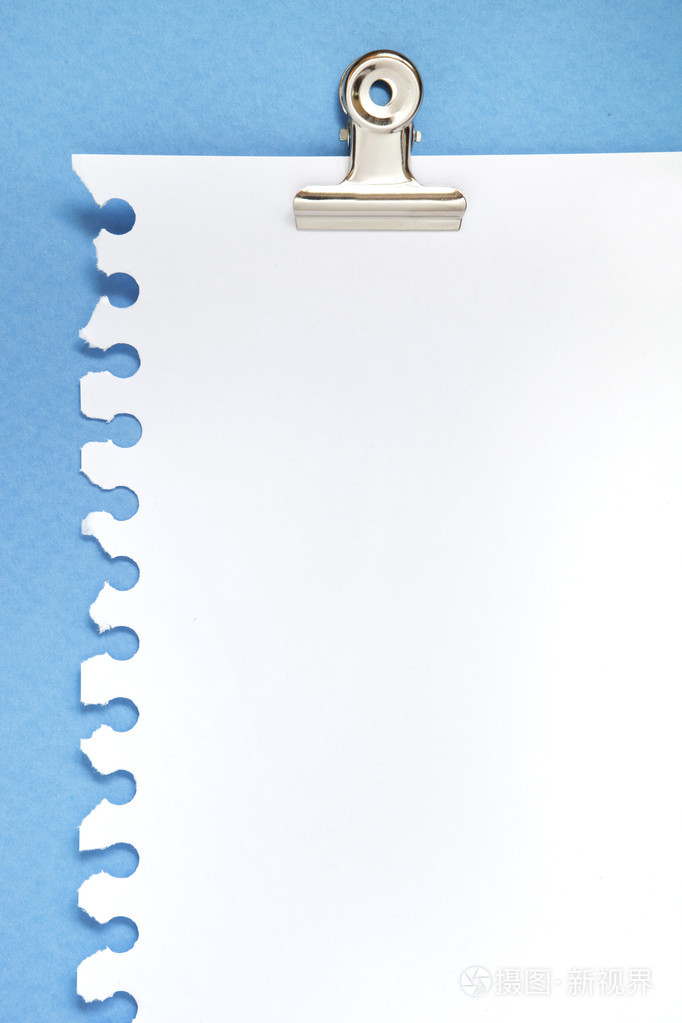 在蓝色背景与剪辑的空白便条纸