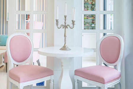 白表和粉色的椅子上，在客厅里的桌子上的蜡烛
