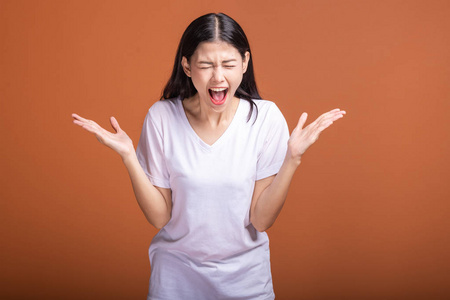 年轻的亚洲时髦女人穿着白 t恤衫, 用大赢的尖叫姿势, 两手举起.