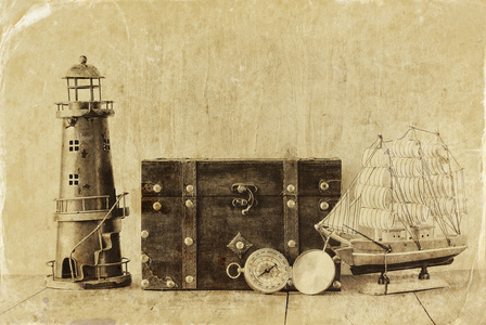 古色古香的罗盘 老式灯塔 木船和老胸部木制的桌子上。黑色和白色的风格老照片