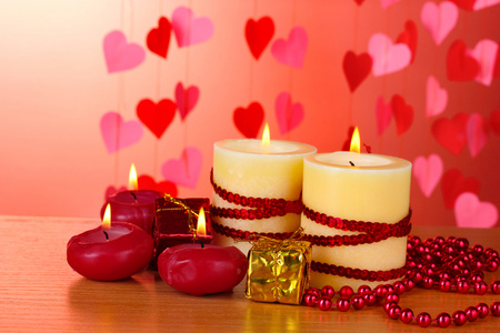 美丽与浪漫装饰红色背景上的木桌上的蜡烛