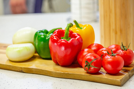 木板上有蔬菜。西红柿, 胡椒, 沙拉开胃的躺在一个木板上的厨房背景