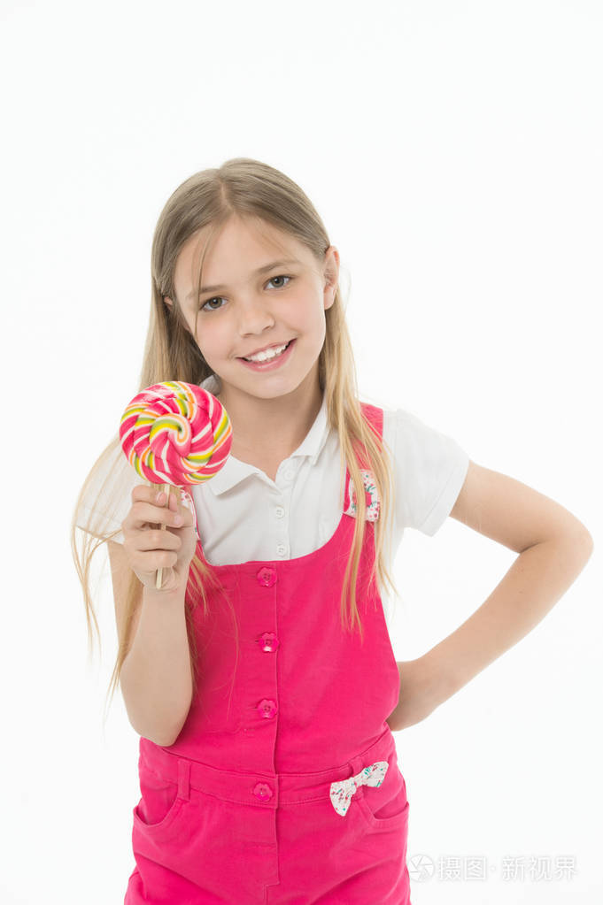 小女孩配棒糖小女孩在棍子上拿棒糖糖.快乐的童年时光.她有一颗甜食.