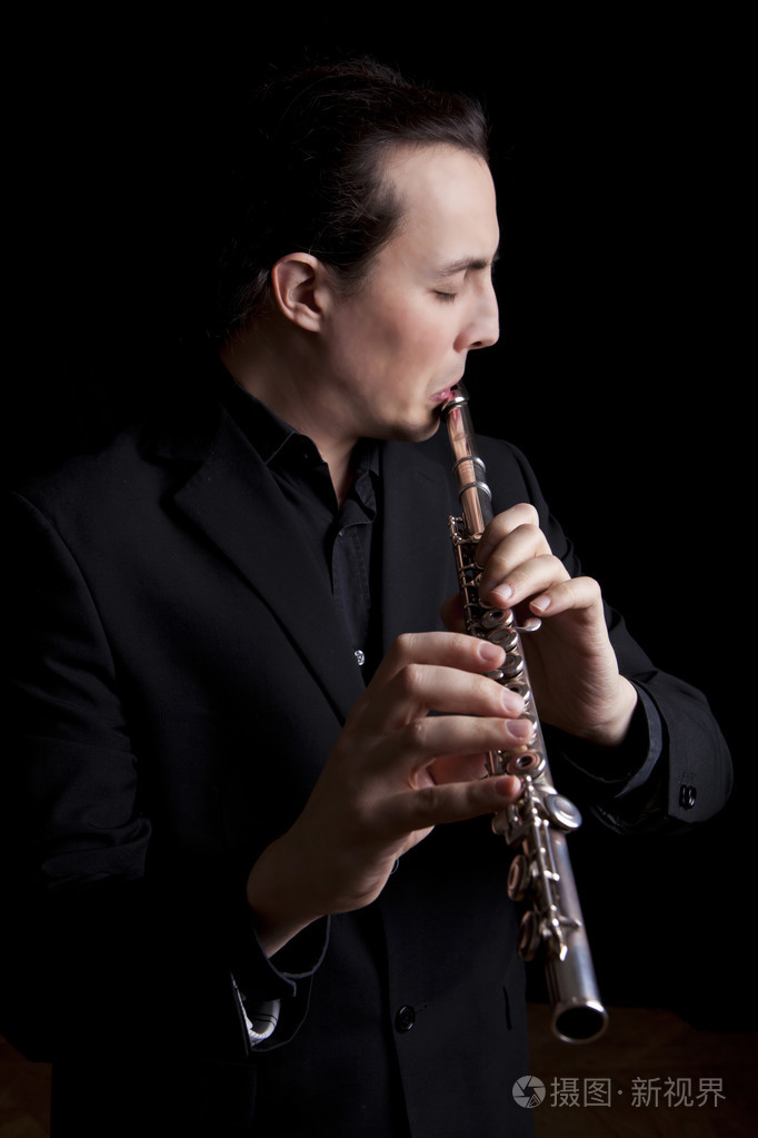 黑色背景上吹长笛专业长笛演奏家音乐家