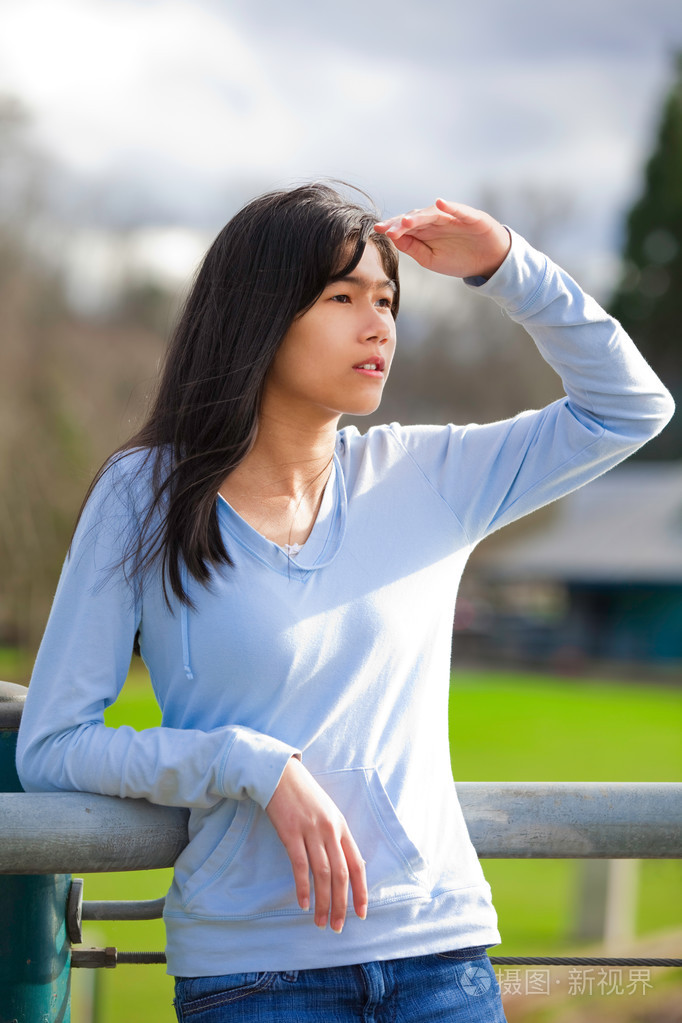 年轻女孩站着倚着栏杆在公园shadin
