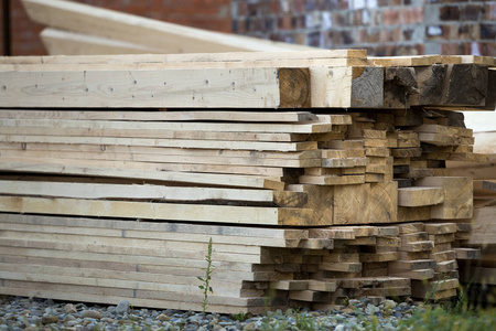 堆放在建筑工地上的天然棕色不平等粗糙木板。木工建筑修理和家具用木材屋面建筑用材