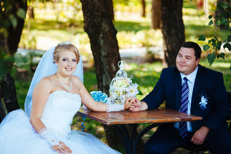 新郎和新娘在结婚当天，新娘捧花与坐在桌旁