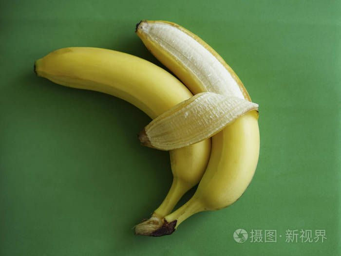 两只香蕉被隔离在绿色背景上爱和柔情符号象征拥抱情侣的概念