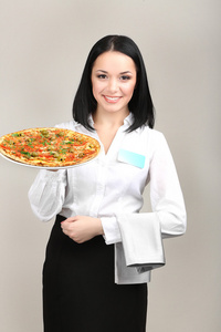 美丽的女孩服务员与披萨上白色隔离
