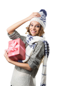 美丽快乐的女孩，在毛衣帽子和手套在白色背景上的圣诞礼物盒的肖像