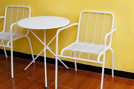 白色的椅子和桌子跟黄墙