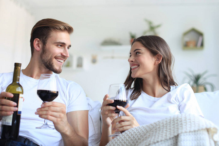 年轻情侣喝一杯红酒在客厅里