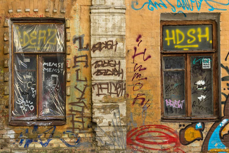 在旧房子的墙上涂鸦。街头艺术。被遗弃的房子的彩绘门面。城市风格。欧洲大城市的功能失调区域