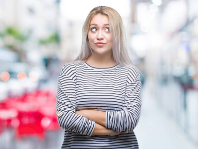 年轻的金发女人在孤立的背景微笑着看一边, 凝视着远离思考