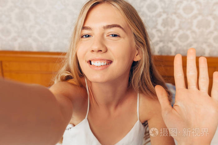 年轻漂亮的女孩带自拍醒来在她的床上早晨照片-正版商用图片0bbo13-摄
