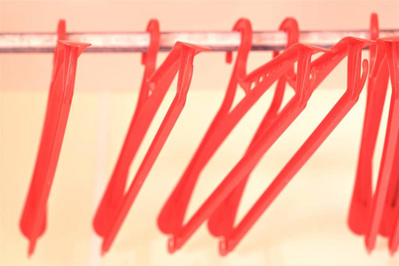 红色塑料衣架在一个空衣柜。软和散景