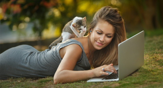 女孩和猫看笔记本电脑