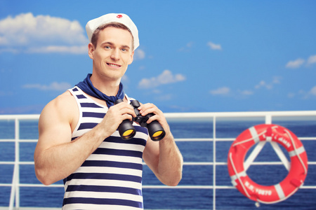 水手在船上拿着双筒望远镜照片