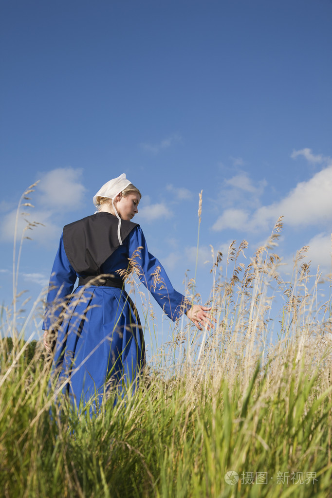 低角度的阿米什人的小女孩走在一个字段的视图