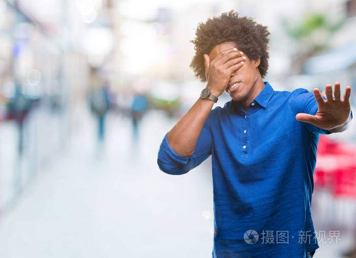 美国黑人在孤立的背景下用手捂着眼睛用悲伤和恐惧的