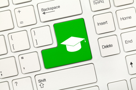 白色的概念键盘绿色键与毕业帽