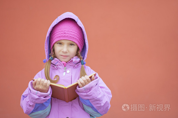 在粉红色的外套小女孩读的书