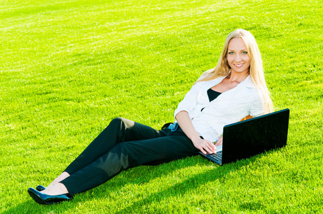 业务的女人躺在草地上