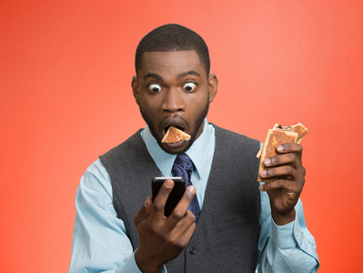 人持有，阅读在智能手机上的坏消息，吃饼干将要窒息