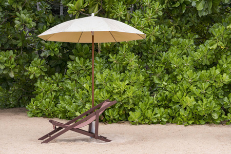 沙滩椅下的奶油伞下的罚款海滩。放松和度假概念