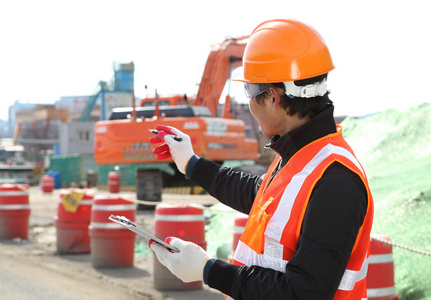 在挖掘机的前面道路建筑工人