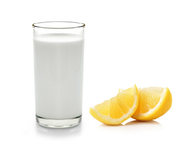 杯牛奶和半柠檬果实白色背景上