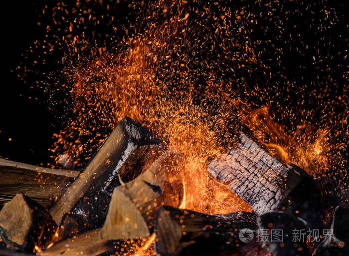 烧毁木原木在火篝火孤立的黑色背景
