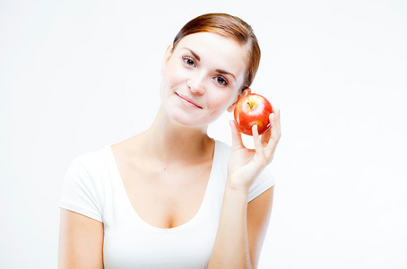 女人抱着和吃红苹果，健康的牙齿