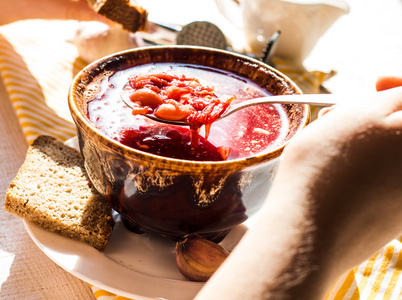 吃红色的罗宋汤，酸奶油，手，陶器的过程